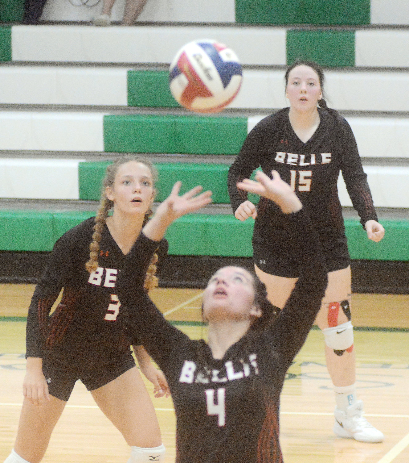 Hali Naber and Morgan Willis (in back, from left) watch the flight path of the volleyball as Belle Lady Tiger teammate Mea Jones sets it during early-September action at New Haven.